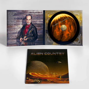Alien Country Album cover - a red planet with sand dunes futuristic city on the horizon with alien moon and flying saucer high above. An antique pickup truck from Earth is driving along a dirt road which leads to the city.