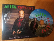 Load image into Gallery viewer, A photo of a CD and it&#39;s sleeve. The Sleeve has a picture of Liam Marcus holding an electric guitar. The CD art is a picture of Liam Marcus standing on a scenic  highway with mountains in the background. Scifi country rock